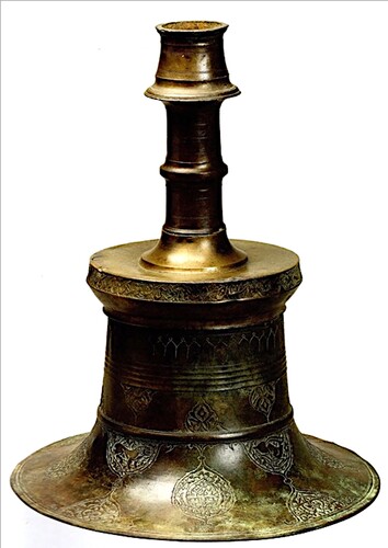 Figure 12. Sotheby’s candlestick. Current whereabouts unknown. 1007/1598–99, Iran. Brass; cast and engraved; h. 37.5 cm, d. 30.5 cm. After Sotheby’s, Arts of the Islamic World, London, 14 April 2010, 115, lot no. 159. Background photoshopped by the current author.