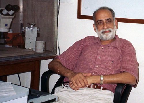 Figure 1. Dr. K. S. Krishnan in his “office” within the laboratory next to the electrophysiology rig in the Department of Biological Sciences, Tata Institute of Fundamental Research, Mumbai, India (circa 2004).