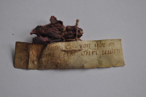 Figure 1. Small bundle containing matter from the Cedron Valley, where pilgrims used to visit Christ’s footprints etched in stone. According to the lettering on the reverse side of the parchment, the relic was brought back to Arth (Switzerland) by the pilgrim Peter Villinger in 1568, which implies that it survived shipwreck and three years of Ottoman captivity. Arth, Pfarrkirche St. Georg und Zeno, relic chest. Image courtesy of Walter Eigel.