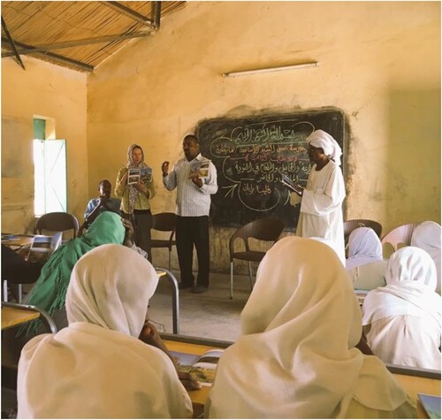Figure 4. Ryan and Hassan Sorta lead an Amara East primary school session with the Nubia Past and Present book, in 2019.