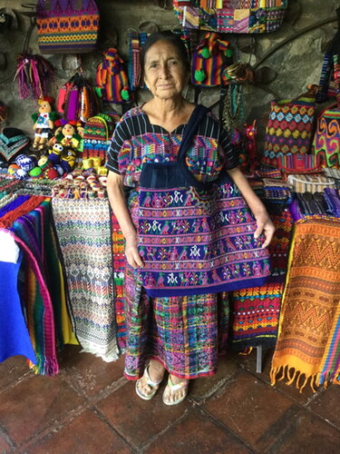 Figure 2 An artisan weaver in Antigua selling items made from deconstructed traje as well as newly backstrap-woven table linen. Photograph by K. Townsend, 2018.