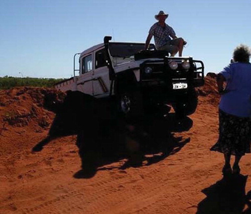 Dr Murray Chapman on the bonnet of his car after impaling the car on a ledge during an advanced 4WD training course