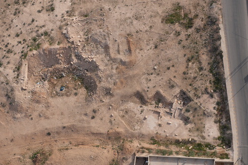 The excavated building with mosaics at Muwaqqar. The wall of the reservoir can be seen to the left amongst spoil (APAAME_20130414_DLK-0013)