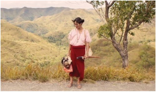 Figure 4. Marlina on her way to the police station, holding the head of the rapist.