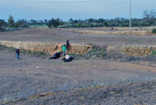 Figure 9. Fieldwork at Vilalta: profiling the terraced field boundary. The rough ashlar walls of the terraced fields are typical of the region. Photo: Sam Turner, November 2014.