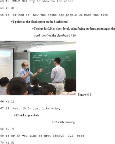 Figure 16. T raises his LH at chest level, palm facing students, pointing at the word ‘how’ on the blackboard.