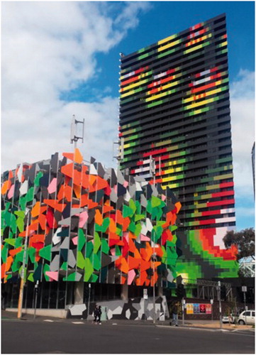 Figure 4. The Grocon Pixel building is an example of a green office building in Carlton near the Melbourne central business district. The multi-level building in the foreground has wind turbines on the roof and adjustable side panels for controlling exposure to solar radiation. If converted into a vertical farm, solar panels could be used on the roof and sidewalls and interior lighting would use high-efficiency LED sources. At nearby Lincoln Square there is a million liter holding tank under construction for local reuse of stormwater. The conceptual model illustrated is the twinning of a residential tower with a vertical farm.
