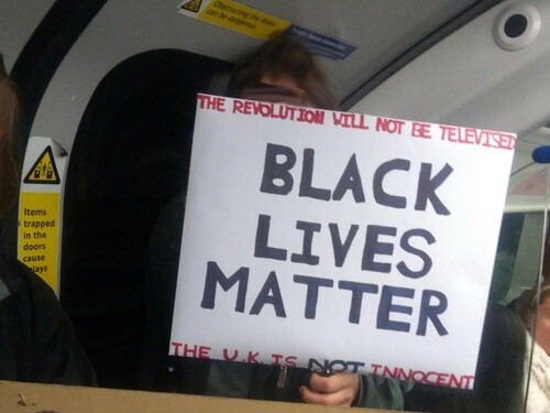 Figure 4. A protest sign reading ‘THE REVOLUTION WILL NOT BE TELEVISED. BLACK LIVES MATTER. THE U.K. IS NOT INNOCENT', held by a protester on a London Underground train. Author’s photo.