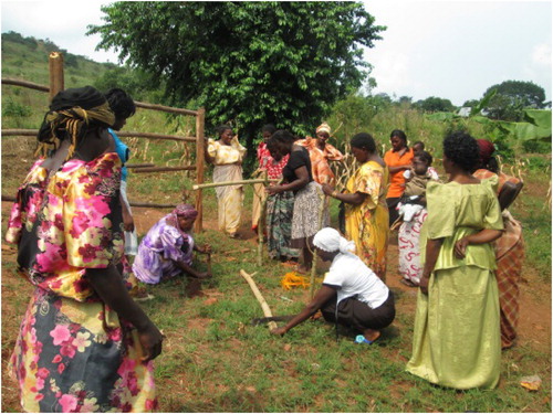 Photo 3. A youth demonstrates to women how to make a drying rack that can be used at households for placing utensils as part of voluntary work in the community.