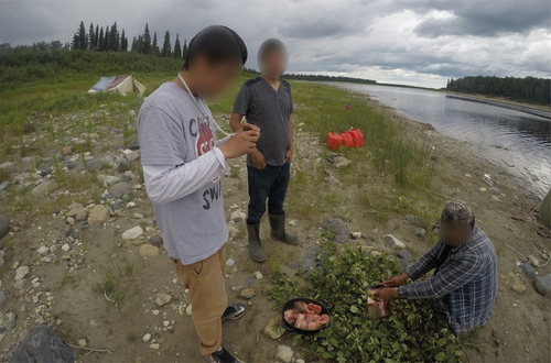 Figure 3. An Elder showing youth participants how to prepare fish. (Photo credit: Participant 12).