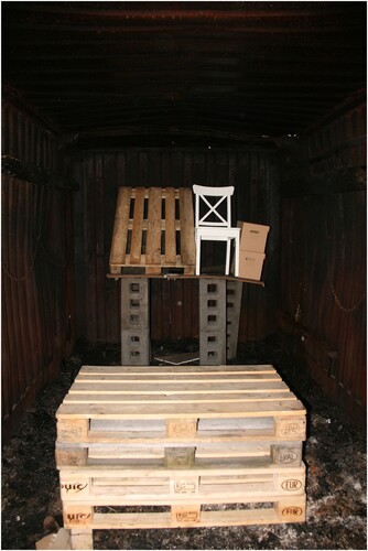 Figure 3. Set-up before covering the items and before igniting the fire using the wooden pallets stacked in front.