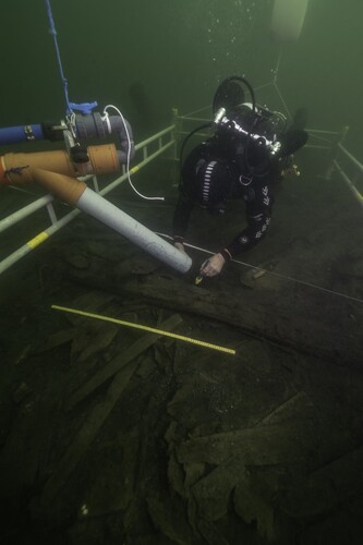 Figure 14. Excavation amidships in 2019 using a dredge. The exposed area is full of remains of barrels and other artifacts. The situation in the trench indicates that the area was disturbed by salvage activity directly after the wrecking in 1495. (Photo: Brett Seymour, The Gripshund Project).