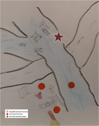 Figure 6. A fishing place (star) in Titinkiem River portrayed on a map drawn by the students in Kumay. The students also regard the river as culturally important (brown sticker). On the other side of the road, the students have marked a place where they regard logging as a problem (red stickers).