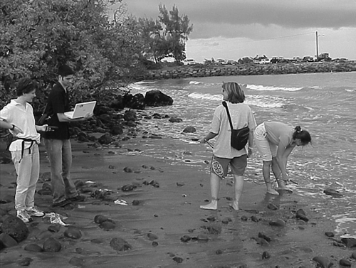 Figure 5.  Collecting and analysing samples from the Pacific Ocean along with GPS coordinates, to compare water chemistry along the shore versus locations along freshwater streams. Photograph by Joseph Kerski, Kahului, Hawaii, during the Maui Digital Bus project institute supported by the My Community Our Earth initiative.