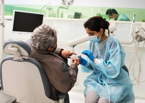 Figure 1. Take the time to communicate with the patient speak directly to patients and maintain eye contact. Remove mask if possible as patients may read lips. Picture courtesy of Jon Draper, Dugoni School of Dentistry.