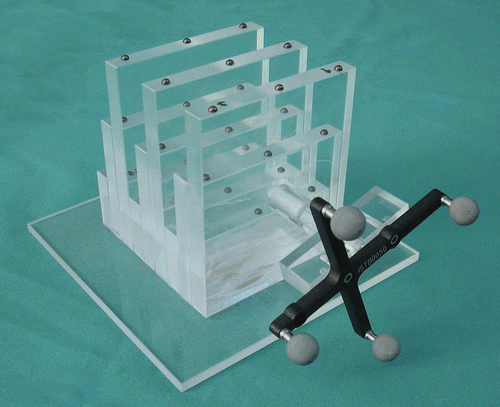 Figure 3. The phantom used in the presented study. It is made of acrylic glass and carries 27 titanium markers arranged in a regular 3 × 3 grid. Here it is shown equipped with a passive reference base.