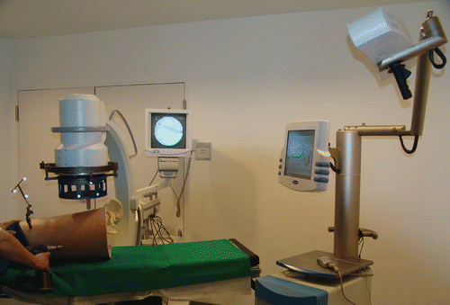 Figure 1. Overall view of the assembly, showing the positioned leg model with attached reference markers, the fluoroscope with its marker device, the infrared camera, and the touch-screen monitor of the navigation system. [Color version available online.]