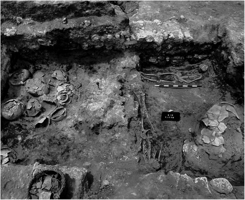 Figure 21 Burials in Square Q/10 (Locus 1770) in Area CC (Harrison Citation2004: fig. 73). Note the relationship between the skeletons on the right, with respect to architecture and the smashed pottery (courtesy of the Institute for the Study of Ancient Cultures of the University of Chicago).