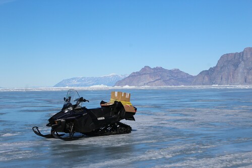 Figure 7. This snowmobile was incapacitated due to overheating on bare shorefast ice in Uummannaq Fjord, May 2019. Lack of snow cover increases difficulty of snowmobile travel over shorefast sea ice. Credit: S. Cooley.