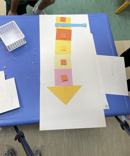 Figure 17. Child O uses blu tack for sticking the paper blocks for the different photo frames for the animation.