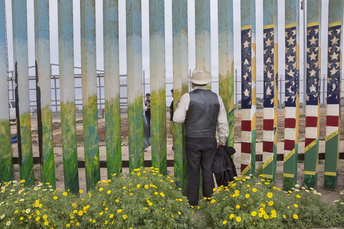 Figure 1. Griselda San Martin, The Wall, 2015–16. José Marquez poses for a photograph that a visitor is taking of his family on the other side of the border wall. Marquez has not been able to hug his daughter Susana in 14 years, since he was deported from the United States after living and working in San Diego for 18 years. Photograph © Griselda San Martin.