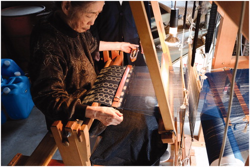 Figure 7 A Kurume gasuri weaver re-aligns the weft yarns as she weaves.