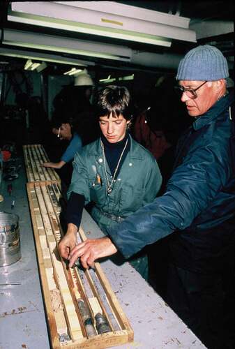 Figure 3. Brian MacLean (right) Anne Jennings (left) aboard CSS Hudson, examining a bedrock core taken with the BIO drill during cruise 85027. Photo courtesy of GSC-Atlantic.
