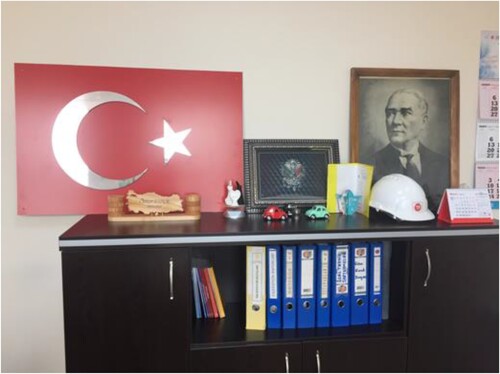 Figure 4. Bekir Bey’s Office: a Turkish flag, the coat of arms of the Ottoman Empire, and a portrait of Mustafa Kemal. (Author’s photo).