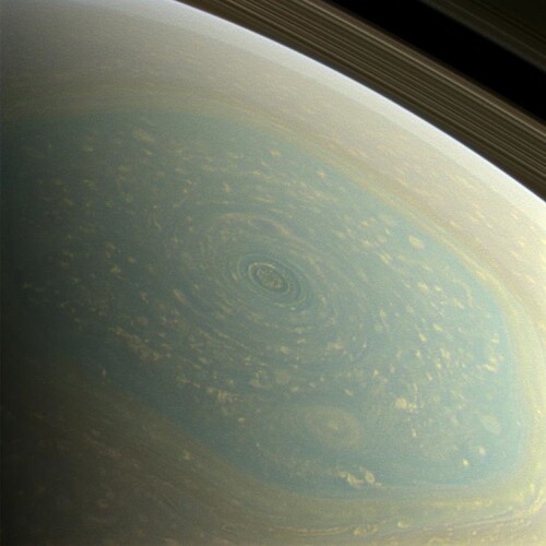 Figure 1. Natural-colour view of Saturn's north polar region down to about 72∘N, acquired on 27.XI.2012 during NASA's Cassini mission, with Saturn's rings visible in the upper right corner (Image Credit: NASA/JPL-Caltech/SSI). The region surrounded by the six-sided jet stream comprises a massive hurricane centred on the pole, north of 88∘N, and numerous small vortices, with the biggest spanning about 3500 km. Some vortices spin clockwise while the six-sided jet stream and the hurricane spin counterclockwise.