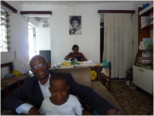 Figure 10 Three generations: Cyrille Goethe in his parlor with his nephew. His daughter Christine (the nephew’s mother) sitting at the table. A portrait of her mother on the wall. (Douala 2014. Copyright Rosario Mazuela)