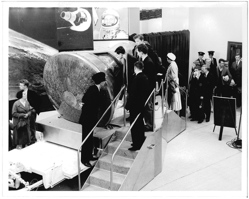 Figure 2. The exhibition was simple. The capsule, lying on a trolley, stood in front of a curved panel with photographs. Visitors could climb on a platform to examine the spacecraft© The Science Museum, London/Science and Society Picture Library.