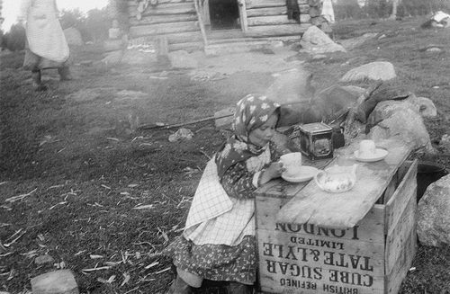 Figure 8. Agni Sverloff, a girl from Suenjel Skolt Sámi sijdd, is having an afternoon tee at the summer place of her family in Beahccam or Petsamo area in 1930s.