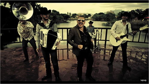 Figure 4. El Komander, with Calibre 50 in Qué tiene de malo (2014), demonstrates “macho” posture, expression, and gesturing. c. Disa Latin Music, a division of UMG Recordings Inc. Posted on YouTube by Calibre50.