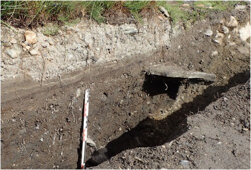 Figure 5. Profile through Tuft 2 at Øsmundset, showing the overturned slab to the right. In the background, the stone-filled embankment is clearly visible in the profile. Photo: Lisbeth Skogstrand, Museum of Cultural History.