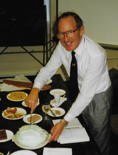 Figure 9. Bill Chaloner at an informal retirement party organised by his students at Royal Holloway, University of London, during the summer of 1994 (subsection 13.1). Bill is pictured making the first slice into a spore cake baked by Alan R. Hemsley; note the prominent trilete mark. Photographer Andrew C. Scott.