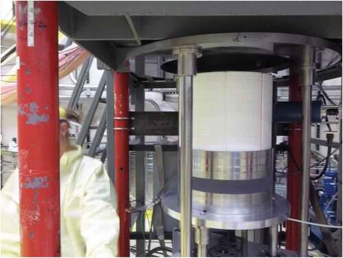 Fig. 7. BeO (white) radial reflector mounted on the movable platen of the Comet vertical assembly machine. Also, bottom 304 stainless steel shield (silver) with a layer of B4C (dark).