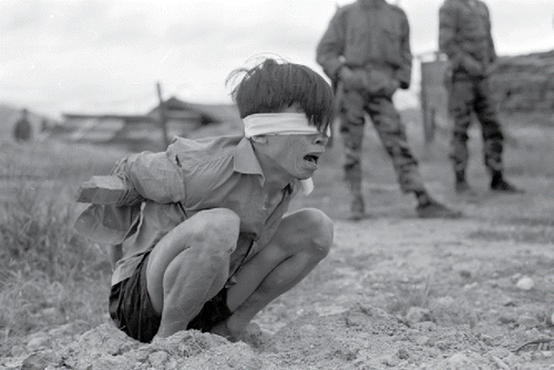 Figure 4. A suspected National Liberation Front prisoner awaits interrogation at a Special Forces Detachment close to Da Nang in 1967. Source: U.S. National Archives, Identifier Number 531447. High-resolution image taken from Wikimedia Commons (https://commons.wikimedia.org/wiki/File:Vietconginterrogation1967.jpg?uselang=en-gb).