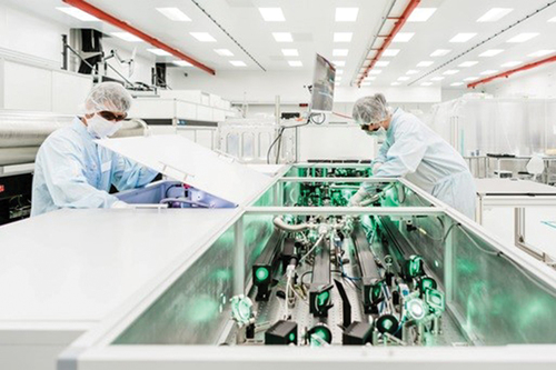 Fig. 7. Operators at work on the laser system. Clean room ISO 7 attire and laser-safety goggles limit movement and visibility, increasing the time needed for each intervention, and consequently, the exposure time.