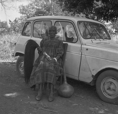IMAGE 5. Senior woman posing by Toussele’s car with signs of rank: e.g. fly whisk and palm wine gourd EAP054/1/124/343_dvd115_053. Reproduced courtesy of Jacques Toussele.