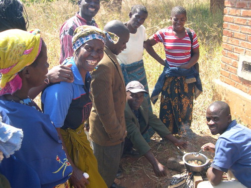 Figure 3. Paul Nkhonjera cooking with other farmers looking on, 8 August 2009. Source: Rachel Bezner Kerr.