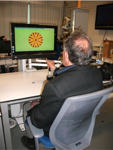 Figure 2 A participant grasping the robot end effector in the setup position.