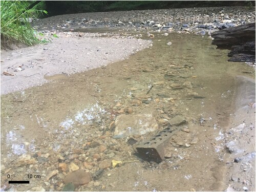 Figure 7. Bricks (foreground) and construction debris observed in the bedload at the confluence of an unnamed tributary and Piney Branch Creek (top of image). Scale is representative of objects in the foreground.
