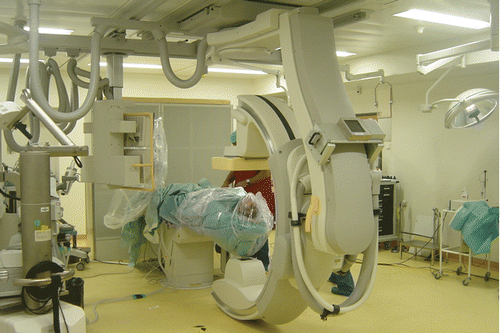 Figure 3. Intra-operative view showing the patient covered with sterile plastic sheets to protect the operating field for the mobile C-arm CBCT scan with a flat-panel detector.