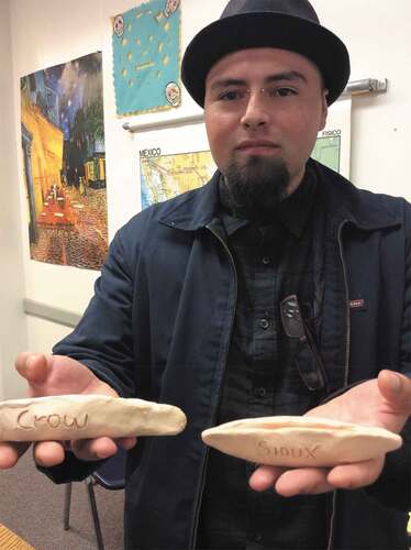 Figure 7. Student showing his Crow and Sioux canoes. Photo by Santiago Andrés Garcia