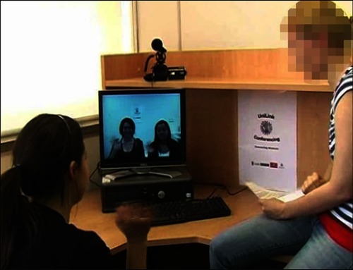 Figure 1 The experimenter (right) introducing the participant (left) to two female students (prerecorded confederates) at the beginning of the experimental interaction.