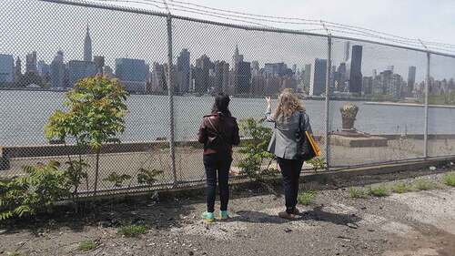 FIGURE 4 Landscape architects assess redevelopment potential of a defunct commercial property on the East River, Brooklyn. City planners are increasingly demanding wide setbacks and creation of publicly accessible riverfronts as terms for redevelopment of former industrial sites (Smith Citation2020) [Access] (Author photo, 2018).