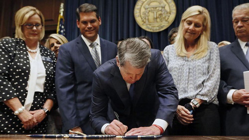Figure 3. Supporters watch Georgia Governor Brian Kemp sign HB 481 into law on 7 May 2019. Photo credit: Bob Andres/AJC.com