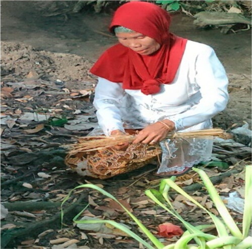 Figure 5. Sendang caretaker prepares ritual uborampe.
