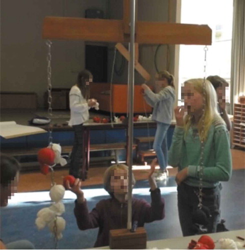 Figure 3. Kees and Julia substitute a red bag for two whites and watch the physical hanging mobile coming into balance (Episode 1).