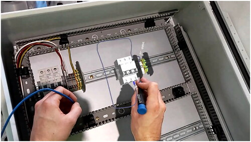 Figure 2. Worker assembling wiring in electrical cabinet with reference hologram—view from Hololens AR HMD.